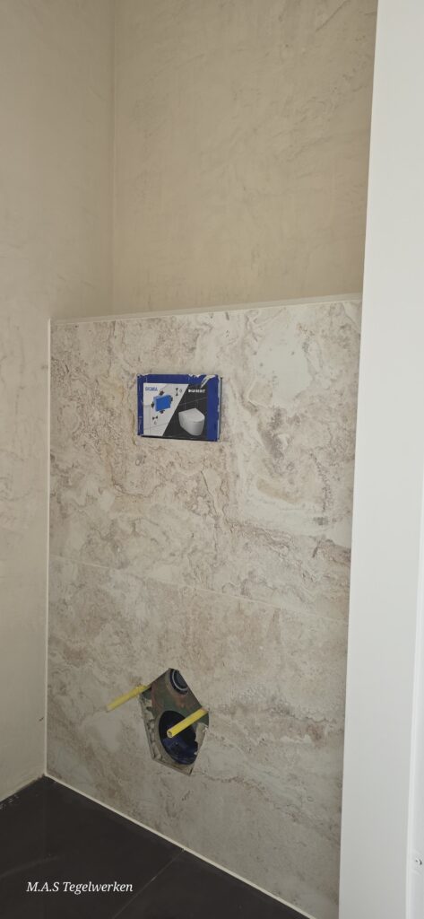 Toiletruimte met inbouwreservoir en zorgvuldig tegelwerk